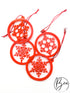 Adornos navideños rojos con copos de nieve dentro de aros y cintas para colgar