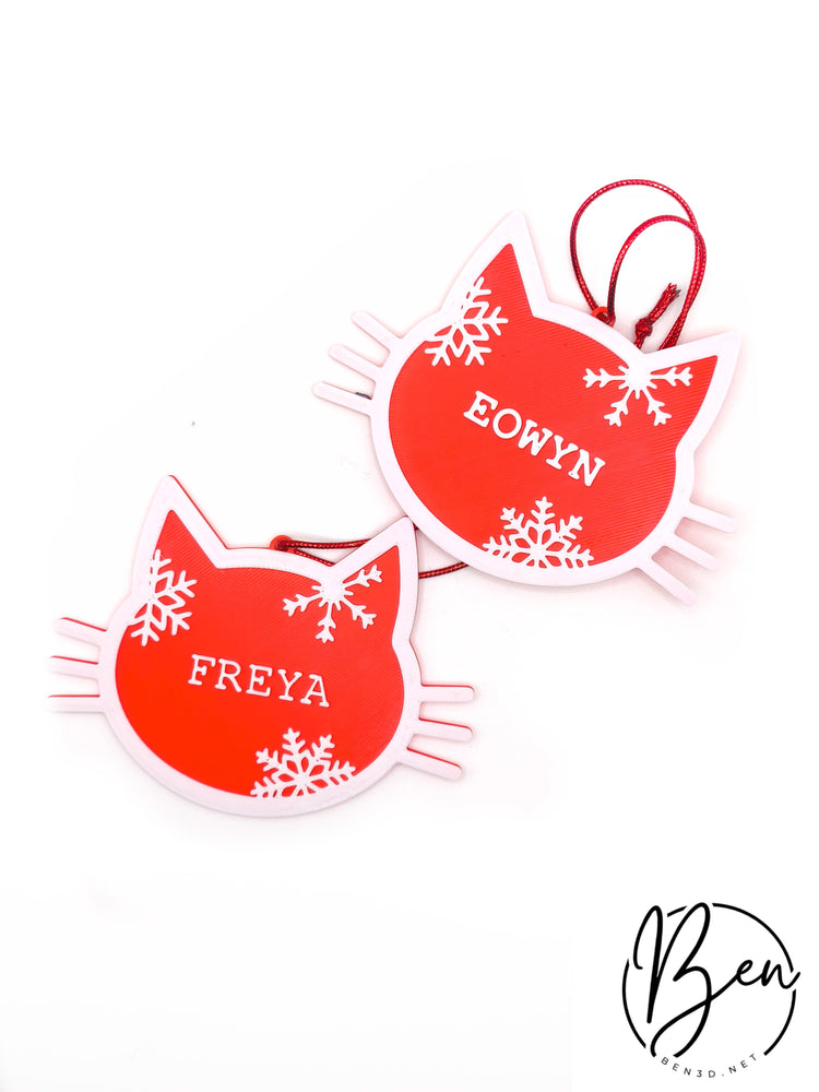 Dos adornos navideños con silueta de gato, nombres personalizados y copos de nieve en rojo y blanco