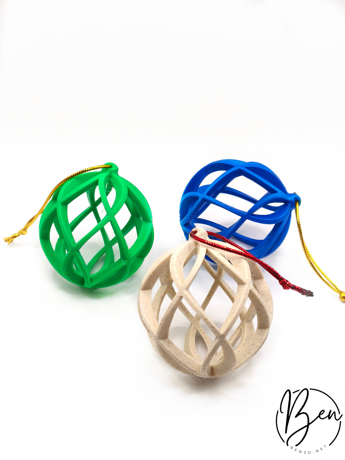 Tres bolas de Navidad de diseño abierto con bandas curvas en verde, azul y beige