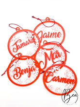 Cinco bolas de Navidad rojas con nombres personalizados y copos de nieve blancos