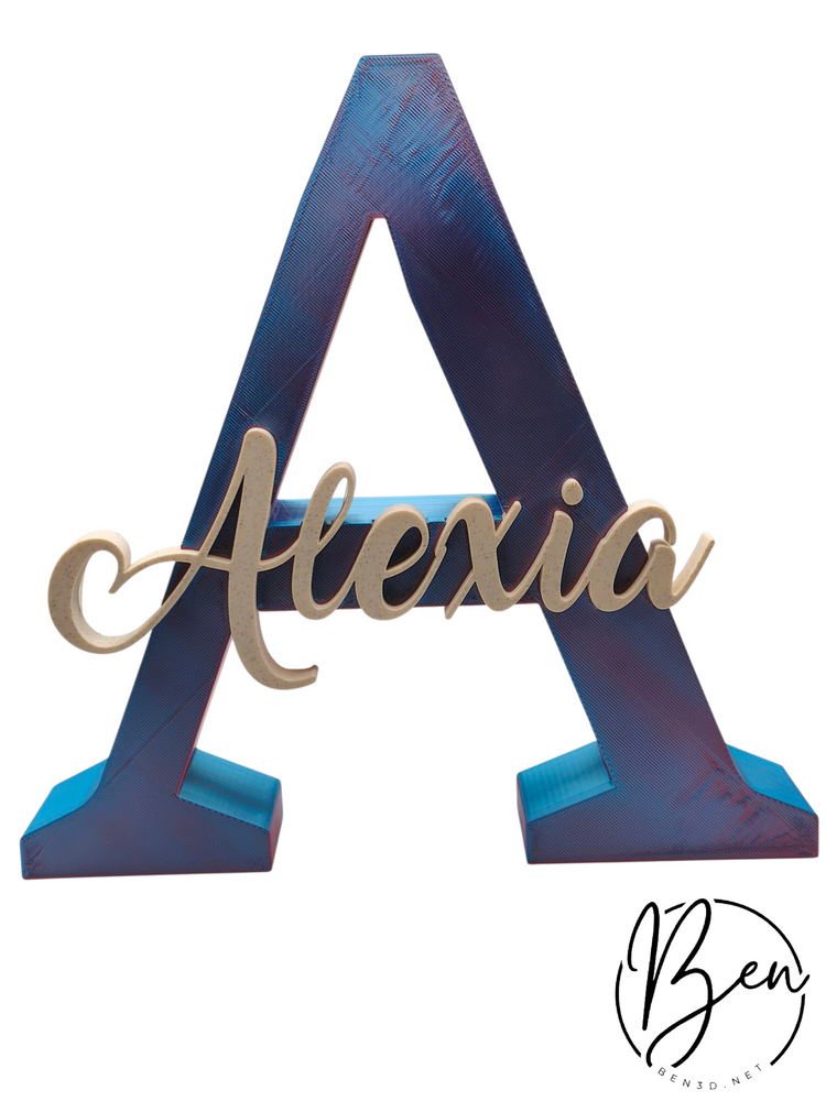 Letra A decorativa en tonos azules con el nombre Alexia en relieve
