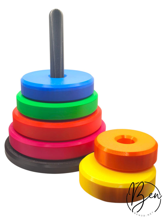 Torre de aros apilables de varios colores con base y eje grises, y dos aros separados